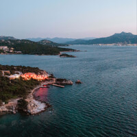 Vista mozzafiato sul mare del Cone Club presso 7Pines Resort Sardinia a Baja Sardinia, con uno splendido mare e luci dell'edificio
